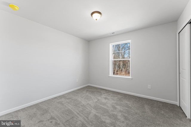 unfurnished bedroom with visible vents, carpet, baseboards, and a closet