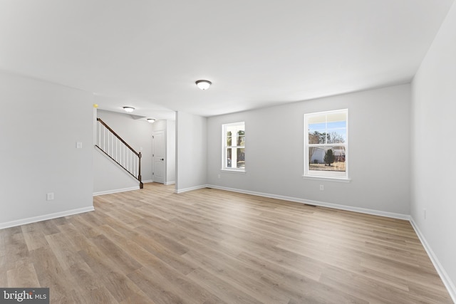 interior space with stairway, baseboards, and light wood-type flooring