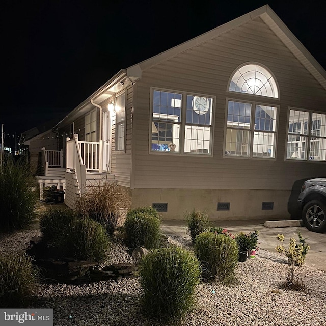 property exterior at night featuring crawl space