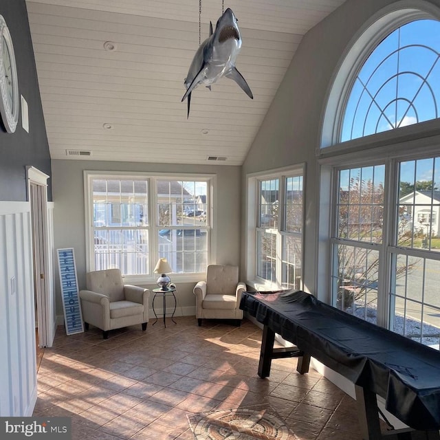 sunroom / solarium with visible vents, a ceiling fan, and vaulted ceiling