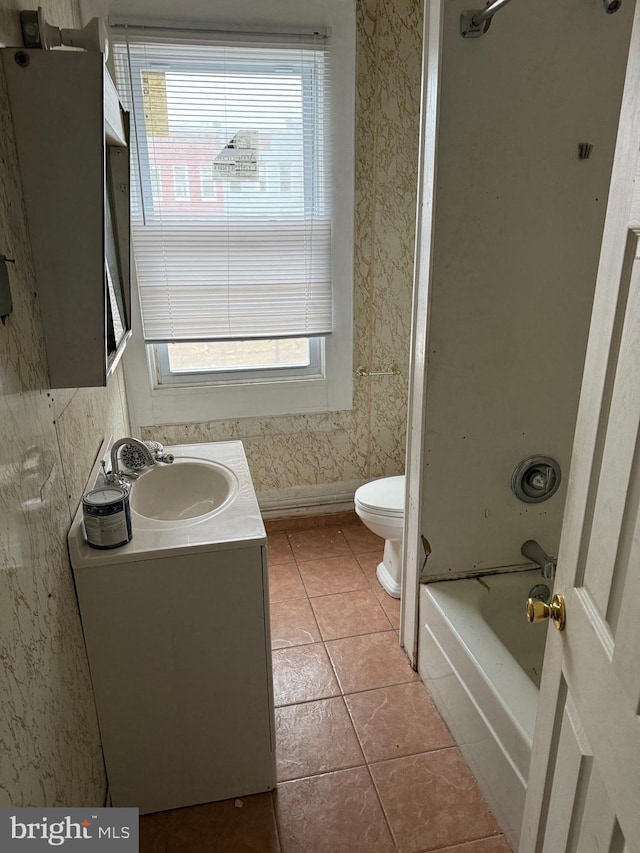 bathroom featuring vanity, baseboards, wallpapered walls, tile patterned flooring, and toilet