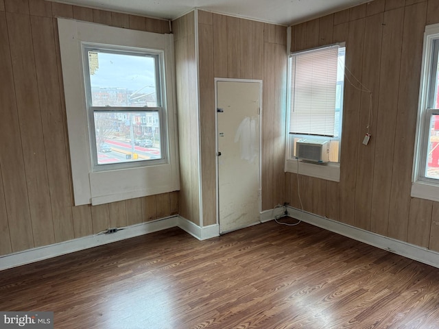 entryway featuring wood walls, cooling unit, baseboards, and wood finished floors