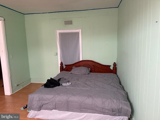 bedroom with visible vents and wood finished floors