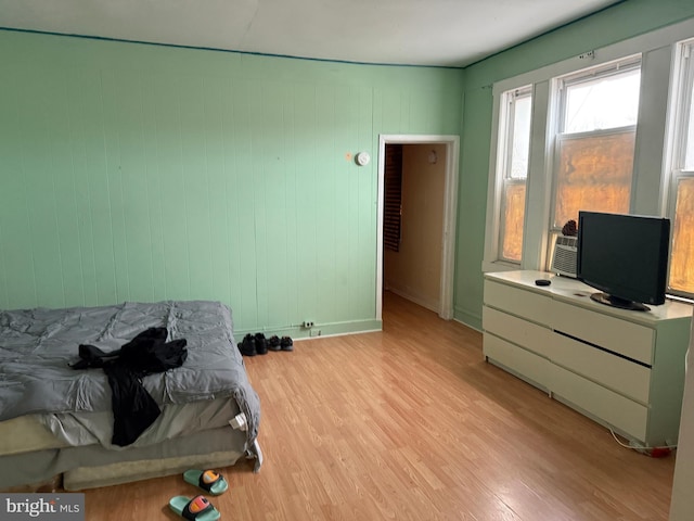bedroom with light wood finished floors and baseboards