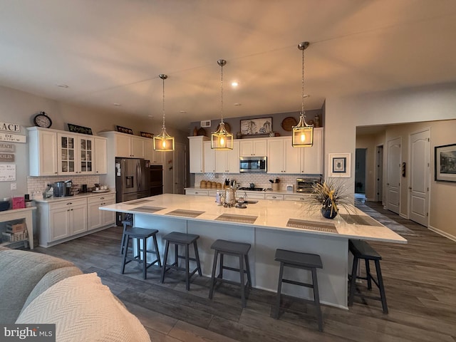 kitchen with stainless steel appliances, a large island, a breakfast bar, and white cabinets