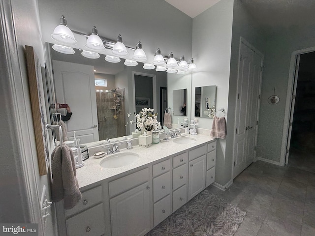 bathroom with double vanity, a stall shower, tile patterned floors, and a sink