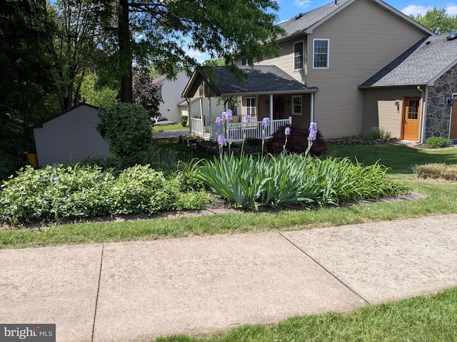 2308 Cypress Dr, Harrisburg, PA 17110 - rear view of house featuring a porch, a shingled roof, stone siding, and a lawn