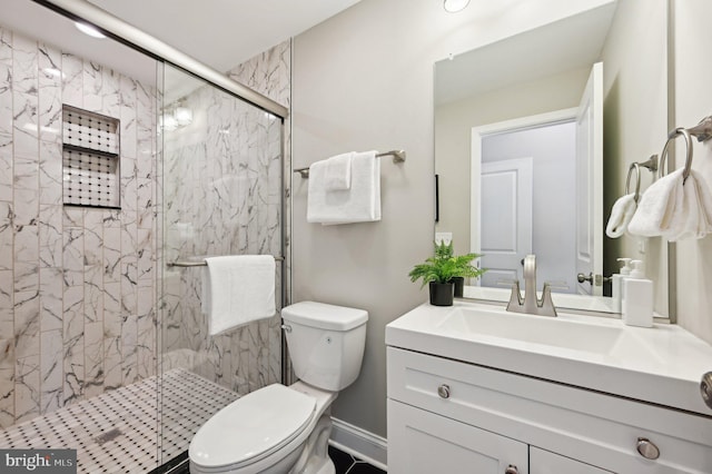 full bathroom featuring a marble finish shower, toilet, and vanity