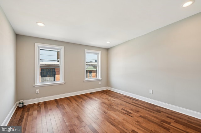 empty room featuring recessed lighting, baseboards, and hardwood / wood-style flooring