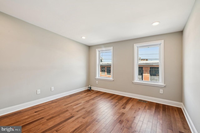 unfurnished room with recessed lighting, visible vents, baseboards, and wood-type flooring