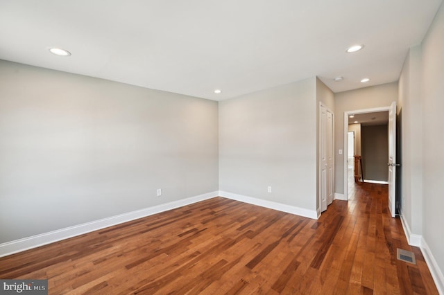 empty room with visible vents, recessed lighting, baseboards, and wood-type flooring