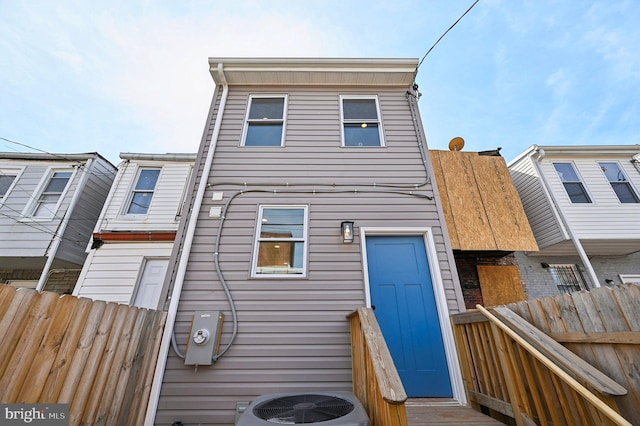 back of house with central air condition unit and fence