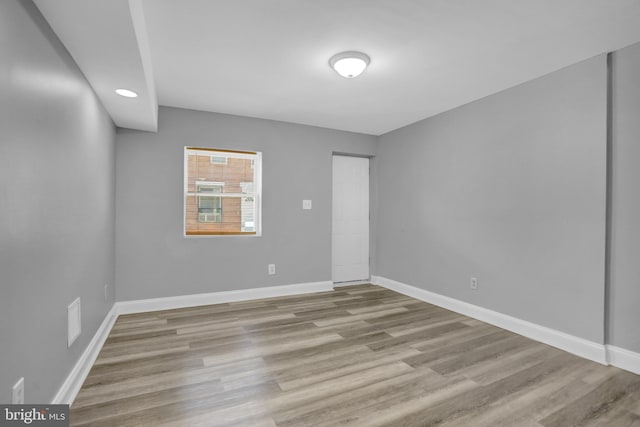 spare room featuring baseboards and wood finished floors