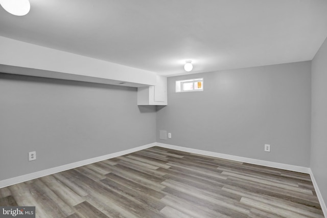 basement featuring wood finished floors and baseboards