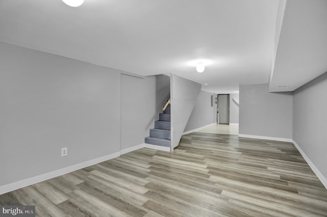 finished basement featuring stairs, baseboards, and wood finished floors