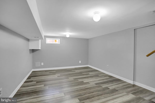 below grade area featuring baseboards and wood finished floors