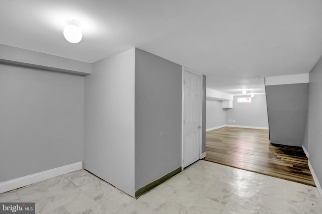 basement with baseboards and marble finish floor