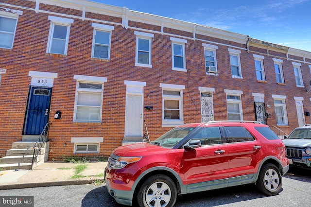 multi unit property with entry steps, cooling unit, and brick siding