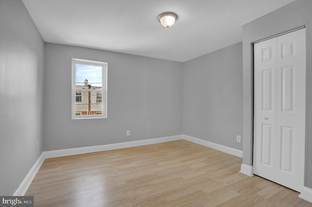 spare room featuring light wood-style floors and baseboards