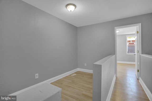 hallway featuring light wood-style floors and baseboards