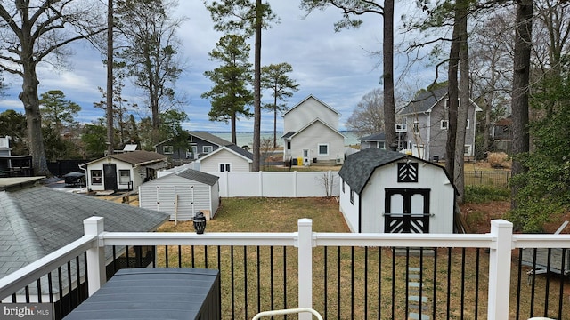 view of yard with a residential view, an outbuilding, a fenced backyard, and a shed