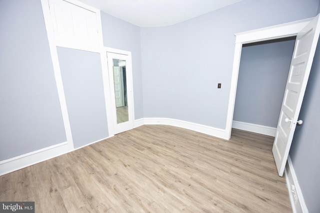 unfurnished room featuring baseboards and wood finished floors