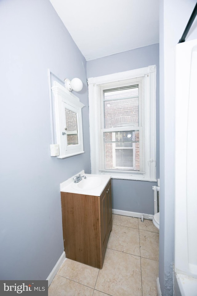 bathroom with tile patterned flooring, vanity, and baseboards