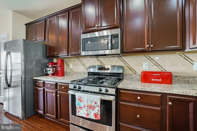 kitchen featuring light stone counters, decorative backsplash, and appliances with stainless steel finishes