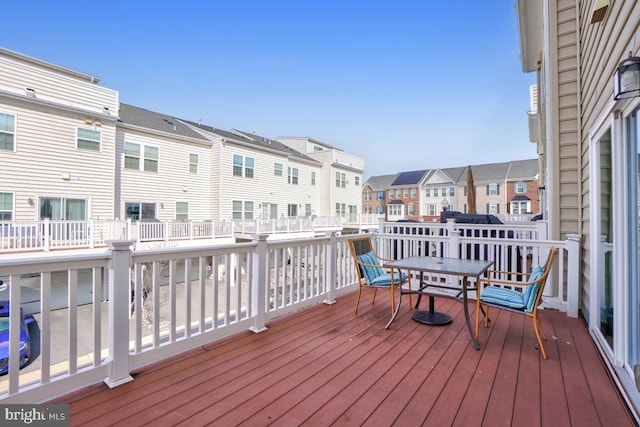 wooden deck with outdoor dining space and a residential view