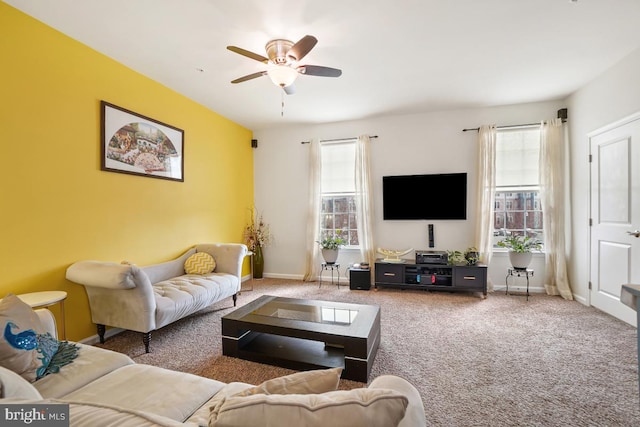 carpeted living area featuring baseboards and a ceiling fan