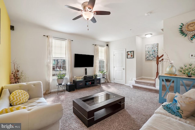 living room featuring stairway, baseboards, carpet floors, and ceiling fan