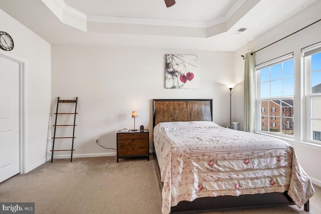 carpeted bedroom with visible vents, baseboards, crown molding, and a tray ceiling