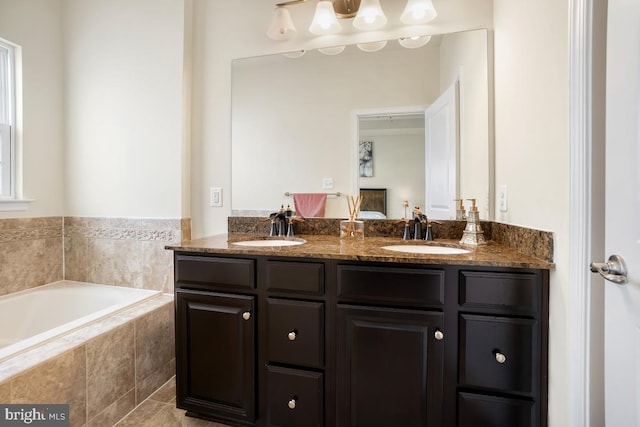 bathroom featuring a sink, a garden tub, and double vanity