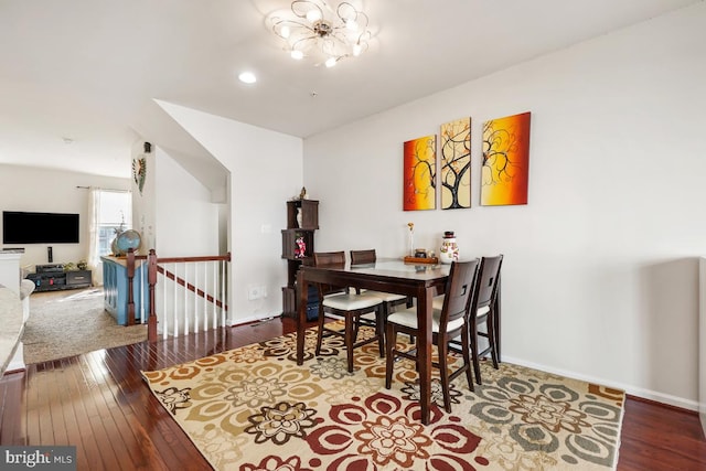 dining room with baseboards, wood-type flooring, and an inviting chandelier