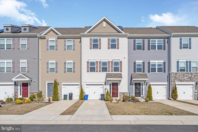 townhome / multi-family property featuring a garage, a residential view, and driveway