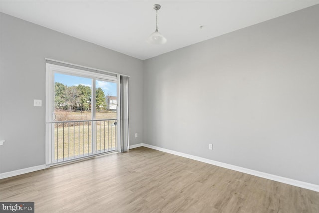 spare room featuring wood finished floors and baseboards