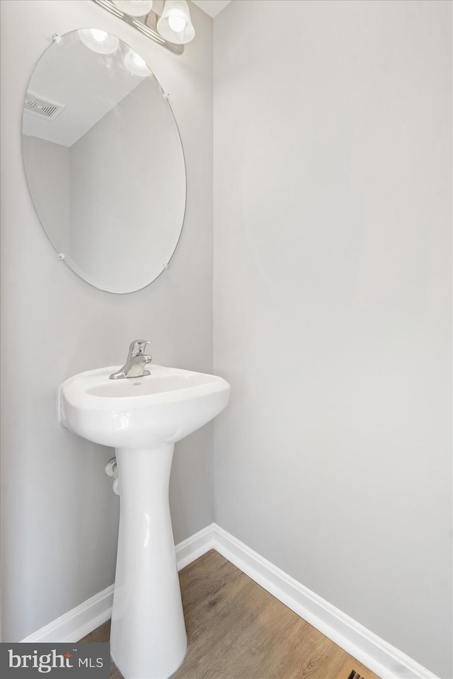 bathroom featuring visible vents, wood finished floors, and baseboards