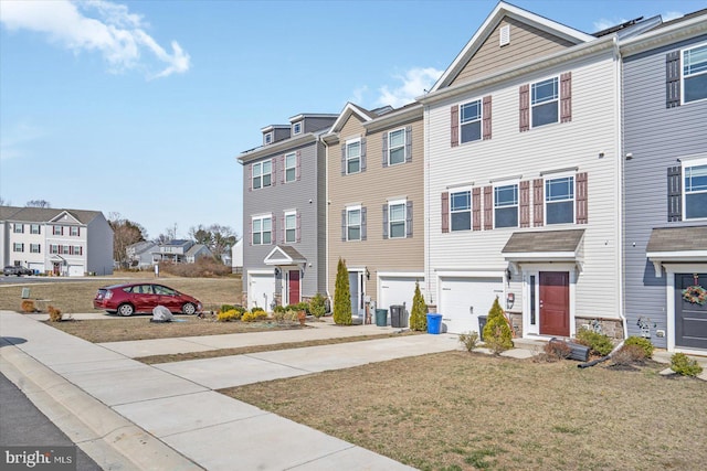 townhome / multi-family property with a residential view, a front yard, concrete driveway, and an attached garage