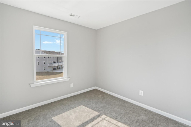 carpeted empty room featuring visible vents and baseboards