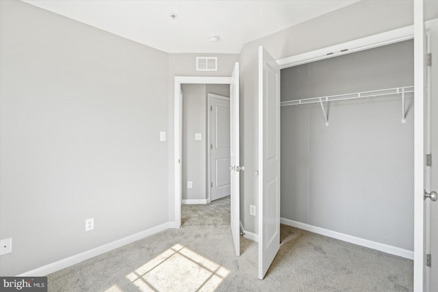 unfurnished bedroom with carpet flooring, baseboards, visible vents, and a closet