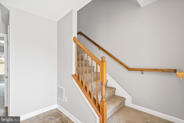 stairs featuring baseboards and visible vents