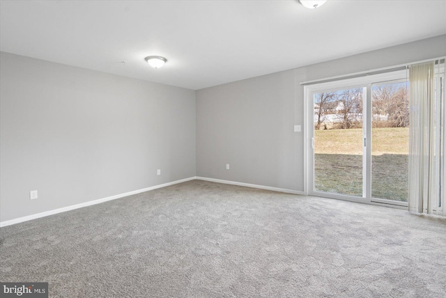 carpeted empty room featuring baseboards