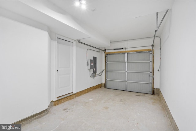 garage featuring electric panel and baseboards