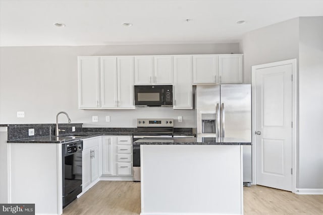 kitchen featuring dark stone countertops, black appliances, white cabinets, light wood-type flooring, and a center island