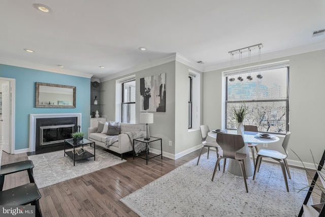 dining space with visible vents, wood finished floors, recessed lighting, crown molding, and baseboards