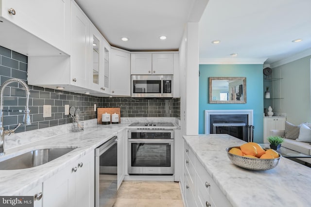 kitchen featuring a sink, stainless steel appliances, white cabinets, and crown molding