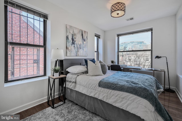 bedroom featuring visible vents, baseboards, and wood finished floors