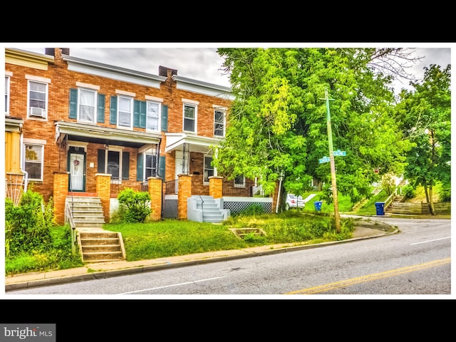 townhome / multi-family property featuring brick siding and covered porch