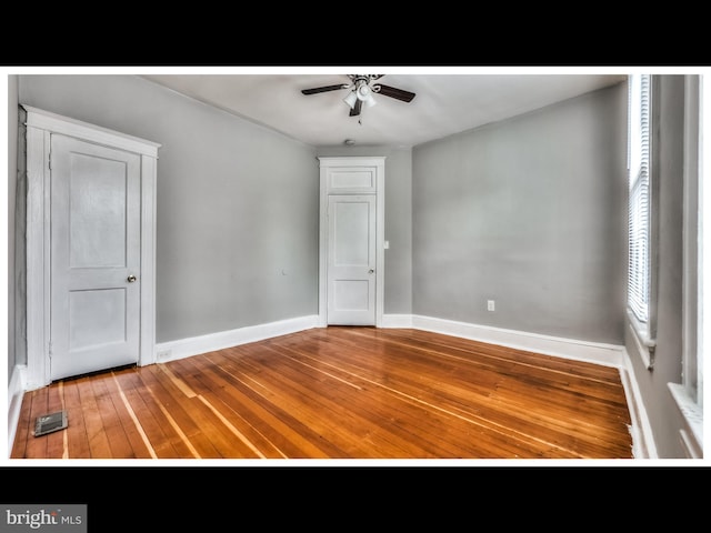 spare room featuring visible vents, baseboards, a ceiling fan, and hardwood / wood-style flooring