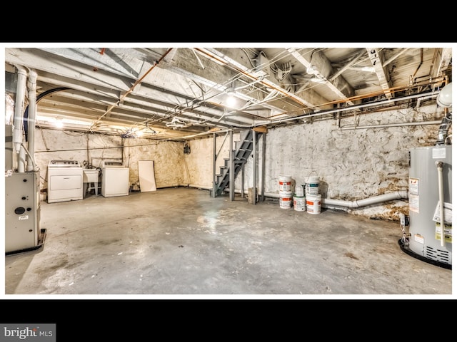 unfinished basement with washing machine and dryer, gas water heater, and a sink